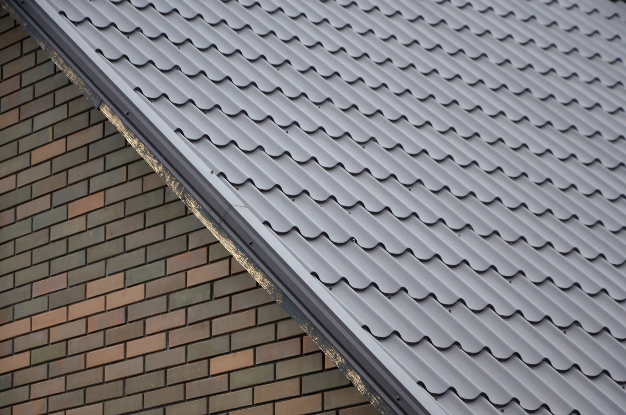 Modern brown roof made of painted metal. Corrugated metal roof and metal roofing industry concept